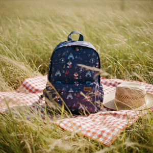 Kinderrucksack Color of the wind auf einer Picknickdecke auf der Wiese