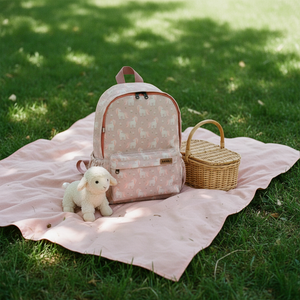 Kinderrucksack cuty unicorn auf einer Picknickdecke im Garten